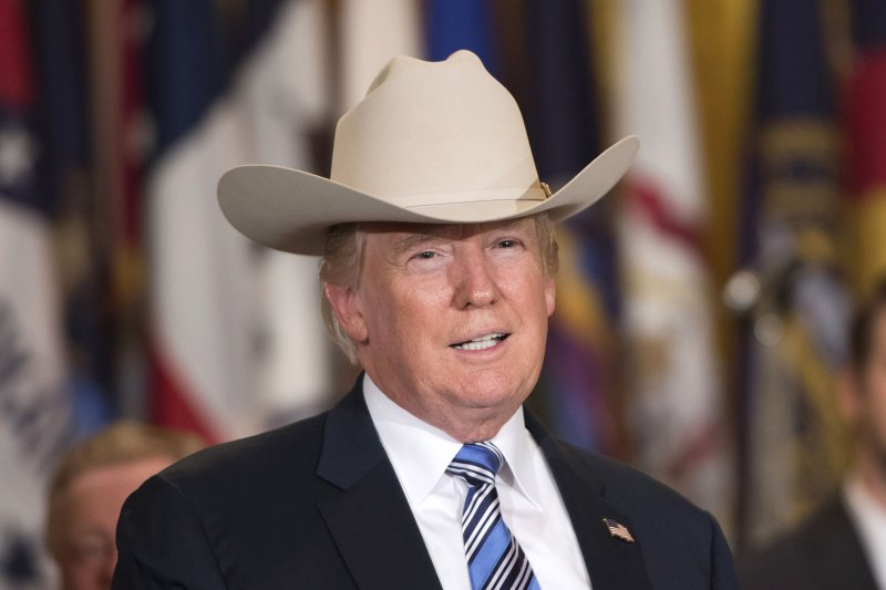 President Donald Trump puts on a cowboy hat